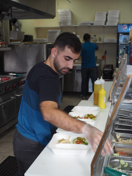 A young man of middle eastern descent prepares food