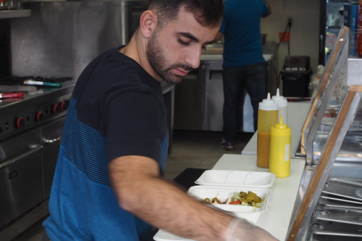A young man of middle eastern descent prepares food