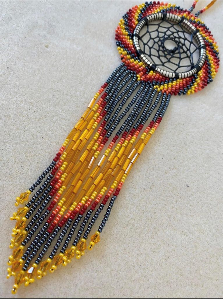 A beautifully beaded dream catcher in red, black and gold